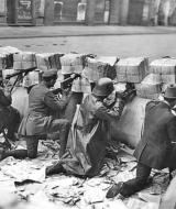 Прибічники німецьких комуністів на барикаді, яку звели з газет, біля  друкарні видавництва Рудольфа Моссе під час повстання «спартакістів». Берлін, Шютценштрассе, 11 січня 1919 року. Фото Віллі Ремера.